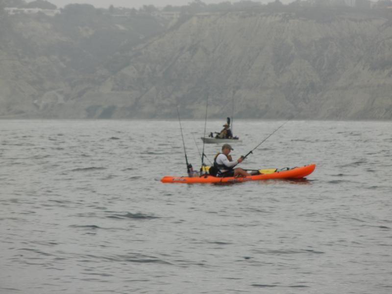 C. Cary reeling in a Yellowtail off La Jolla. Blacks Beach in background.